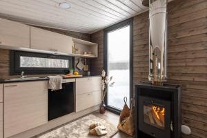 cocina con chimenea y fogones en VADELMA Lapland Riverside Cabin with Sauna Fireplace BBQ Ski Ylläs River Pet WiFi, en Äkäslompolo