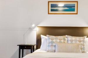 a bedroom with a bed and a lamp on a table at Windsong at Ravensbourne Escape 1 Bedroom in Ravensbourne