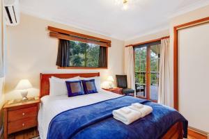 um quarto com uma cama com duas toalhas em Cedar Lodge - Cosy Mountain Retreat 1 Bedroom em Ravensbourne