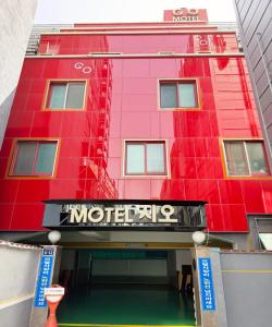 un bâtiment rouge avec un panneau de motel devant lui dans l'établissement GO Motel, à Busan