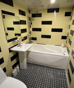 La salle de bains est pourvue d'une baignoire blanche et d'un lavabo. dans l'établissement GO Motel, à Busan