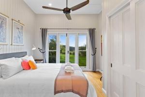 a bedroom with a bed with a ceiling fan at The Quince Cottage - 3 Bedrooms in Ravensbourne