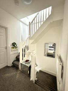 a white staircase in a house with a stair case at Luxury Ensuite Rooms @ Kingsley Terrace in Newcastle upon Tyne