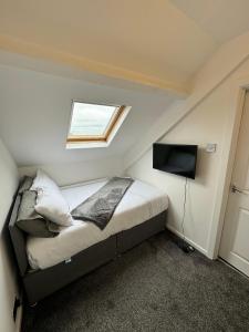 a small bedroom with a bed and a television at Luxury Ensuite Rooms @ Kingsley Terrace in Newcastle upon Tyne