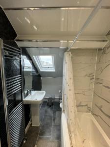 y baño pequeño con lavabo y bañera. en Luxury Ensuite Rooms @ Kingsley Terrace, en Newcastle