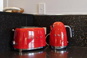 duas chávenas de café vermelhas sentadas num balcão em Affinity Luxury Studio with Spa and Amazing Views em Ravensbourne