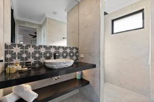a bathroom with a sink and a mirror at Affinity Luxury Studio with Spa and Amazing Views in Ravensbourne +20 photos