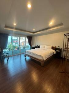 a bedroom with a bed and a large window at Chris Jay @ CNX in Chiang Mai