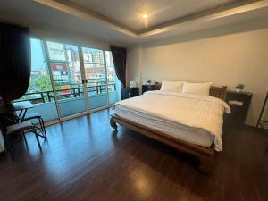 1 dormitorio con cama grande y ventana grande en Chris Jay @ CNX en Chiang Mai