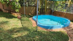 a swimming pool in a yard with an umbrella at Cocoon Earth Home - Pool Villa Kovalam in Kovalam