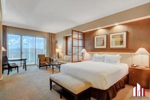 a hotel room with a large bed and a desk at MGM Signature-33-711 F1 Track & Strip View Balcony in Las Vegas