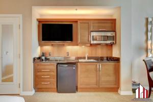 a kitchen with wooden cabinets and a sink and a microwave at MGM Signature-33-711 F1 Track & Strip View Balcony in Las Vegas