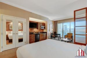 a hotel room with a large bed and a kitchen at MGM Signature-33-711 F1 Track & Strip View Balcony in Las Vegas +53 photos