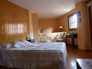 a bedroom with a bed and a desk and chairs at La Antigua Fonda De Villel in Villel