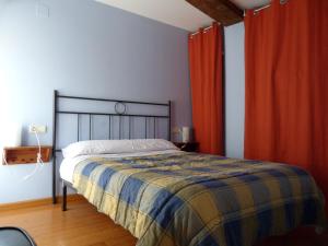 1 dormitorio con 1 cama y cortinas rojas en La Antigua Fonda De Villel en Villel