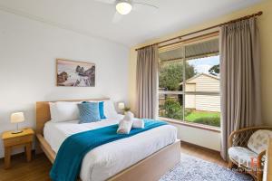 a bedroom with a bed and a large window at Charming 3-Bedroom Retreat in Cowes