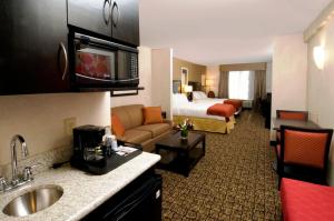 a hotel room with a bed and a bathroom at Holiday Inn Express & Suites Alexandria - Fort Belvoir, an IHG Hotel in Alexandria