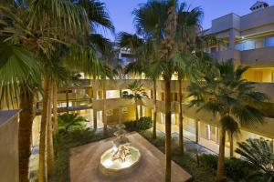 una vista exterior de un edificio con palmeras en Elba Costa Ballena Beach & Thalasso Resort, en Costa Ballena