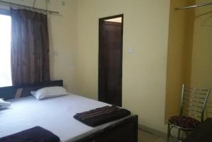 a bedroom with a bed in a room with a window at Hotel Kashi Inn Varanasi By GRG in Varanasi