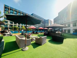 a patio with chairs and an umbrella and a pool at Laguna Beach resort 2-projector loft room in Jomtien Beach