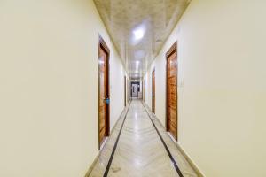 einen Korridor mit weißen Wänden und einem langen Flur in der Unterkunft Vishwakarma Palace in Neu-Delhi