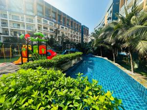 a swimming pool in front of a large building at Laguna Beach resort 2-projector loft room in Jomtien Beach