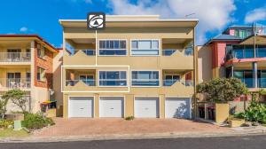 a building with four garage doors in front of it at Avalon 1 in Yamba