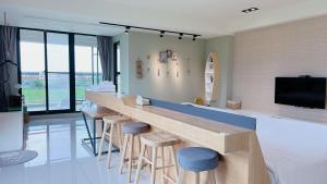 a kitchen with a bar with stools and a tv at Wei Wei Chu B&B in Zhuangwei