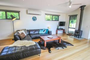 a living room with a leather couch and a table at The Base Two in Harrietville