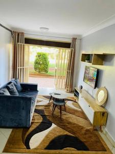 uma sala de estar com um sofá e uma mesa em The Lavish Condo -Wandegeya em Kampala