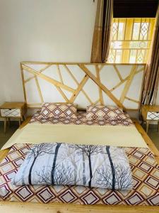 a bedroom with a bed with a wooden head board at The Lavish Condo -Wandegeya in Kampala