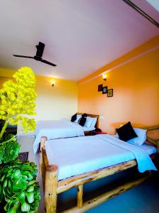 two beds in a room with yellow walls at JMT Eco-Binsar by StayApart in Panuānaula