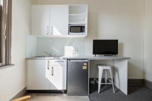 una pequeña cocina con escritorio y ordenador. en Falcon Lodge, en Sídney