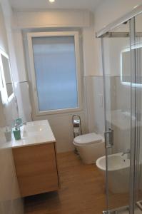 uma casa de banho com um lavatório, um WC e uma janela. em corso francia suite em Roma