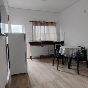 - une cuisine avec une table et des chaises dans la chambre dans l'établissement N03 Apartamento para até 4 hóspedes em Jacutinga, à Jacutinga