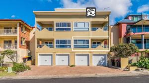 a large apartment building with white garage doors at Avalon 2 in Yamba