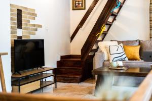 a living room with a television and a couch at Slona, Heritage Home in Old Town Plovdiv in Plovdiv