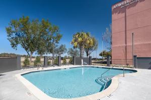 a swimming pool in front of a building at Atwell Suites Austin Airport by IHG in Austin