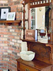 a mirror and a basket on a table in front of a brick wall at Little Hollywood Suite @ The Historic Kanab Inn in Kanab