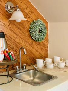 a kitchen sink with cups and a wreath on the wall at Little Hollywood Suite @ The Historic Kanab Inn in Kanab