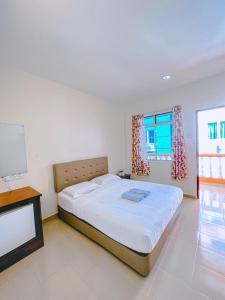 um quarto com uma cama grande e uma televisão em Amzar Motel Cenang em Pantai Cenang