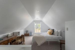 - une chambre blanche avec un lit et un bureau dans l'établissement Classic 1800s Charmer with WiFi and Parking, à Latrobe