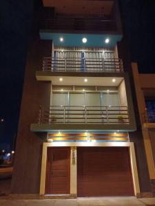 ein hohes Gebäude mit einem Balkon und einer Tür in der Unterkunft Estadía Palmira, Moderno departamento 2 piso in Chiclayo