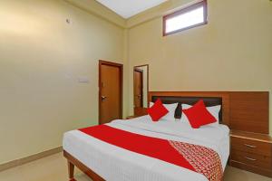 ein Schlafzimmer mit einem großen Bett mit roten Kissen in der Unterkunft OYO Flagship Kk Guest House in Hasanganj