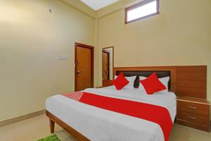 1 dormitorio con 1 cama grande con almohadas rojas en OYO Flagship Kk Guest House, en Hasanganj