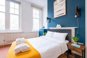 a bedroom with a large white bed and blue walls at Sunny Corner Apartment in Center of London (2) in London