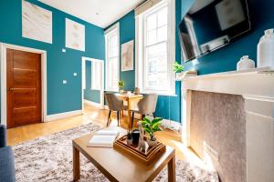 een woonkamer met blauwe muren en een open haard bij Sunny Corner Apartment in Center of London (2) in Londen