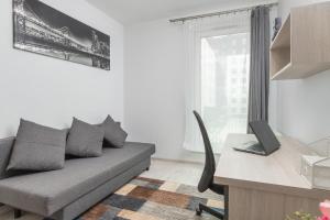 a living room with a couch and a desk with a laptop at Harmonia Oliwska 25 Apartment with Balcony by Renters in Gdańsk