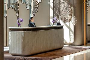 a woman is sitting at a reception desk at Imperial Lexis Kuala Lumpur in Kuala Lumpur