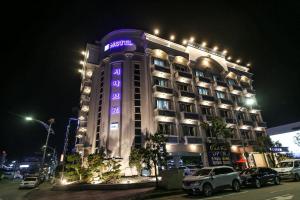 a hotel building with a purple sign on it at night at Sokcho Sinabro in Sokcho